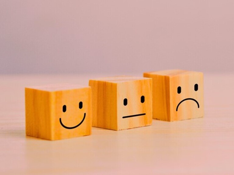 Drei Holzklötzchen mit Smiley-Gesichtern