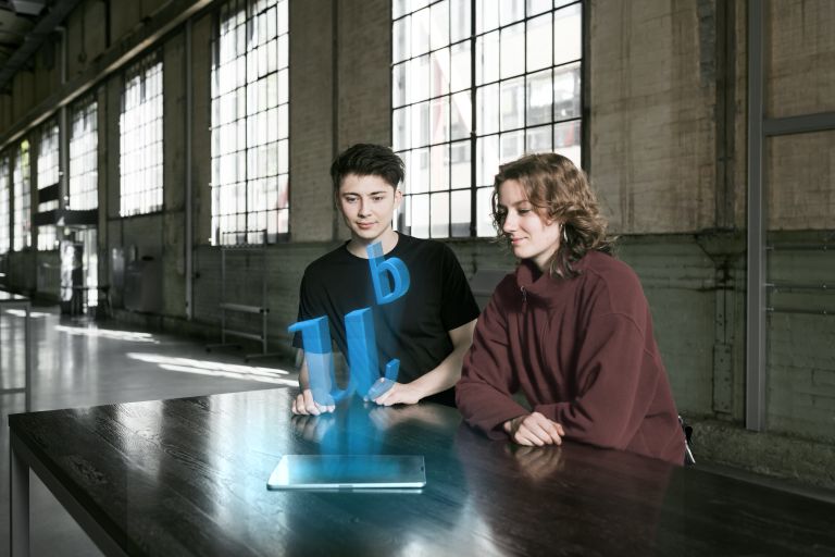 2 students sitting at a table in a foyer